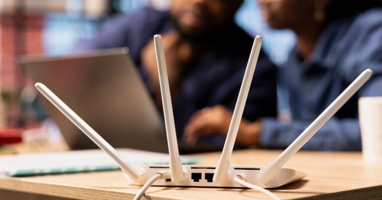 A white router on a desk.